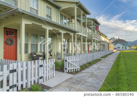 Apartment complex with light green siding and white picket fence at Daybreak, Utah Apartment complex with light green siding and white picket fence at Daybreak, Utah 86580140