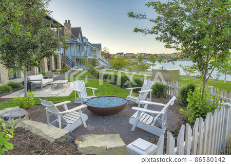 Outdoor patio of a house with fire glass on a fire pit bowl at Daybreak, Utah 86580142