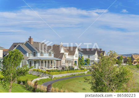 Front yards of large two-storey houses with white picket fences at Daybreak, Utah 86580223