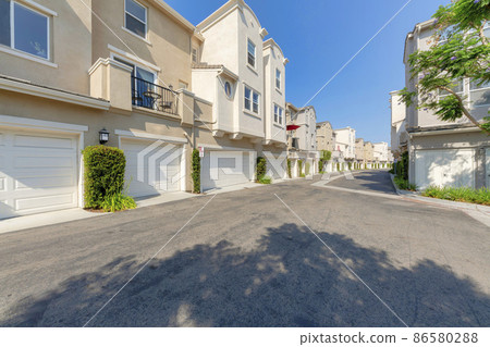 Cream colored townhouses with attached garage asphalt driveway Cream colored townhouses with attached garage asphalt driveway 86580288