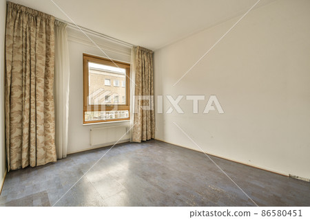 interior of an empty room with stylish patterned curtain and a window interior of an empty room with stylish patterned curtain and a window 86580451
