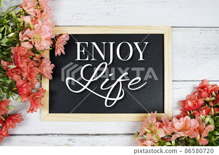 Enjoy Life text on blackboard with flower bouquet decoration 86580720