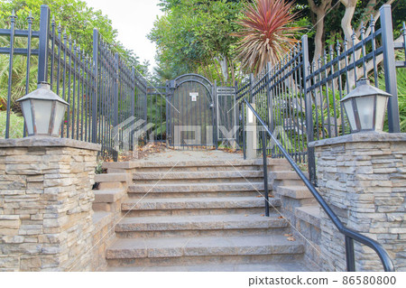 Wrought iron gate and fence with a view of trees and plants at Oceanside, California 86580800