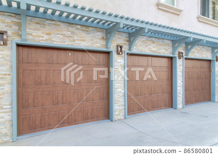 Garage exterior with wall-mounted light blue pergola and doorframe Garage exterior with wall-mounted light blue pergola and doorframe 86580801