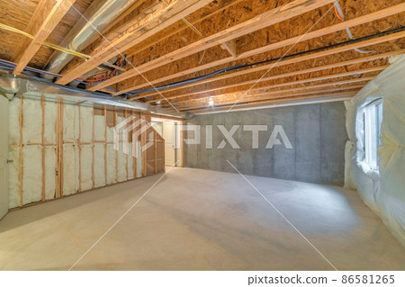 Unfinished basement with a plastic vapor barrier on the wall Unfinished basement with a plastic vapor barrier on the wall 86581265