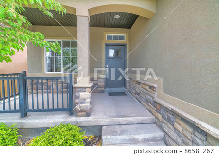 Porch exterior of a house with stone veneer siding and metal railings 86581267