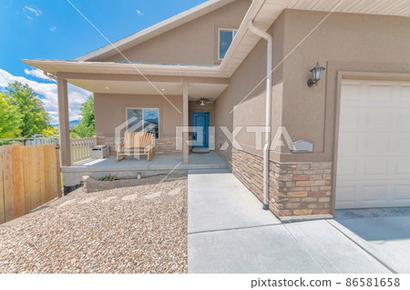 Front porch of a house with wooden bench and blue front door 86581658