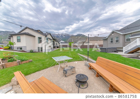 Outdoor lounge with two wooden benches and covered fire pit Outdoor lounge with two wooden benches and covered fire pit 86581758