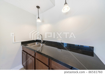 Kitchen sink with black granite top and dark wood drawers and cabinets Kitchen sink with black granite top and dark wood drawers and cabinets 86581760