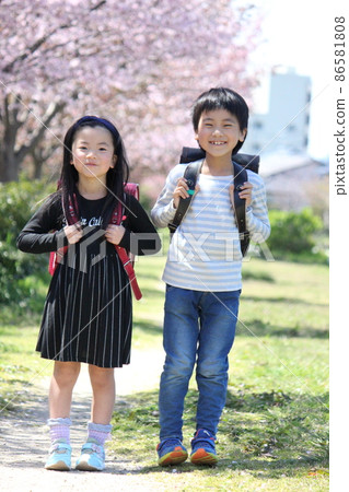 小學男生和女生背著書包笑著看著鏡頭 小學男生和女生背著書包笑著看著鏡頭 86581808