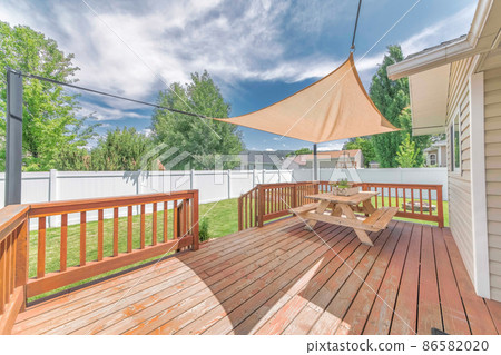 Wooden deck with a sunshade over the table with bench seats Wooden deck with a sunshade over the table with bench seats 86582020