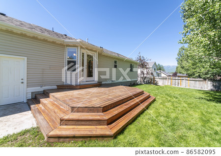 House with wooden layered deck and white back door with glass and side panel House with wooden layered deck and white back door with glass and side panel 86582095