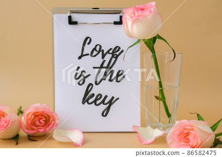 LOVE IS THE KEY text on greeting card paper note. Delicate pink roses on beige background. Minimal trendy composition. Romantic pastel pink rose flowers. Neutral earth tones. Preparation for LOVE IS THE KEY text on greeting card paper note. Delicate pink roses on beige background. Minimal trendy composition. Romantic pastel pink rose flowers. Neutral earth tones. Preparation for 86582475