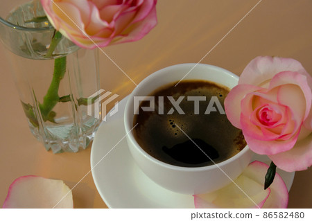 Tender pink rose on vase with white cup of coffee on beige background. Minimal composition. Romantic pastel pink rose flower. Modern aesthetic. Neutral earth tones. Holiday morning breakfast Hardlight 86582480