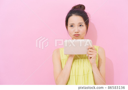 Female in her 20s, pink background, lack of money 86583136