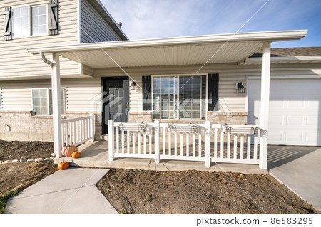Exterior of a house with white vinyl wood and bricks siding 86583295