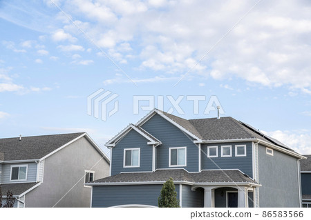 Low angle view of two-storey houses with gray and blue sidings Low angle view of two-storey houses with gray and blue sidings 86583566