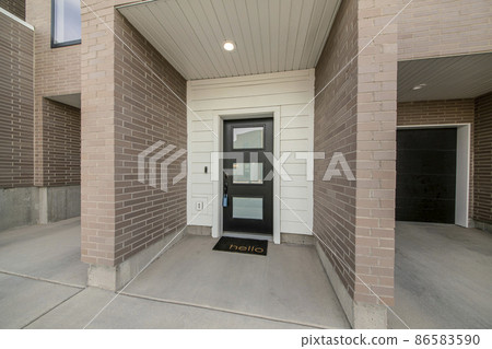 Entrance of a townhouse with lockbox on the black door with glass panels Entrance of a townhouse with lockbox on the black door with glass panels 86583590