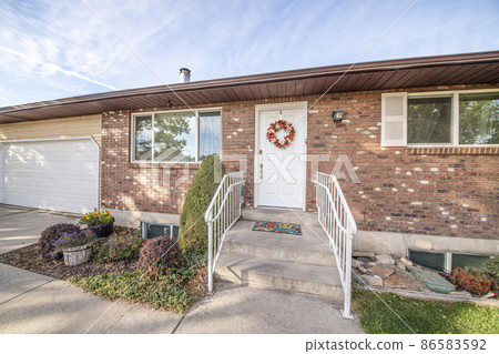 Facade of a house with brown bricks siding and garage 86583592