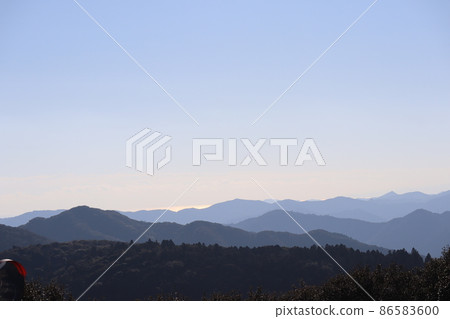 A landscape where you can see the mountains that connect to the blue sky and the sea on the surface of the sea that shines in light orange A landscape where you can see the mountains that connect to the blue sky and the sea on the surface of the sea that shines in light orange 86583600