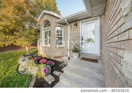 Entrance of a house with bricks and white front door with ornate glass and lockbox Entrance of a house with bricks and white front door with ornate glass and lockbox 86583628