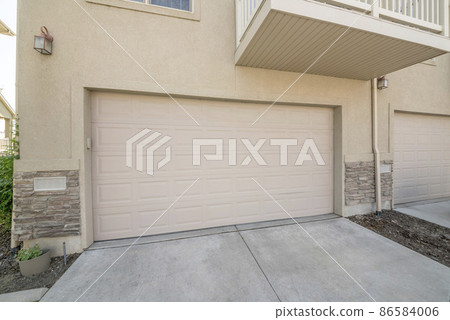 Beige sectional garage doors of a townhouses with balcony Beige sectional garage doors of a townhouses with balcony 86584006