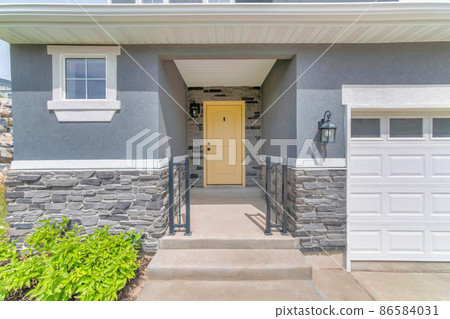 Facade of a house with gray wall sidings and garage 86584031