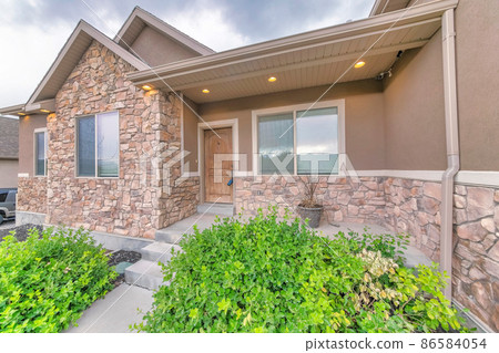 Exterior of a house with stone veneer wall and wooden door with lockbox 86584054