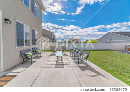 Large outdoor patio with chairs and table on the rug 86584079