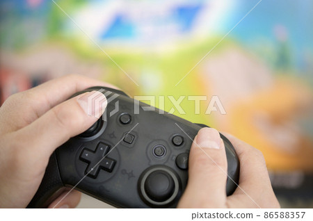 The person who plays the game (controller and hand) 86588357