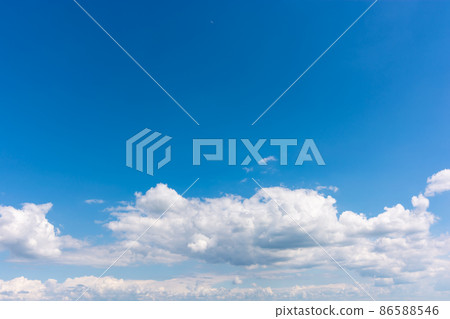 Low floating white clouds in a clear blue sky. Low floating white clouds in a clear blue sky. 86588546