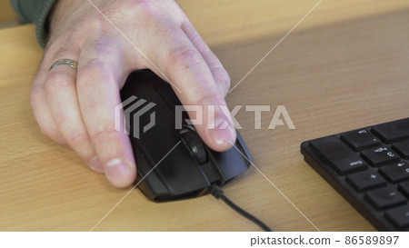 Businessman scrolls the mouse, clicks and works on the computer in the office. Hand on the mouse. The concept of using technology for quick success. 86589897