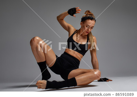 Portrait of female anger, animal instinct, demonstrating their incredible flexibility with the movement of animal flow in the studio on a gray background. Portrait of female anger, animal instinct, demonstrating their incredible flexibility with the movement of animal flow in the studio on a gray background. 86591089