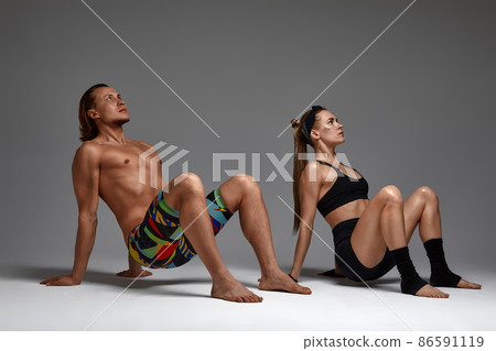 Beautiful young acrobats or gymnasts on gray background. Professional ballet couple dancing, Emotional duet performing choreographic art. Animal instinct 86591119