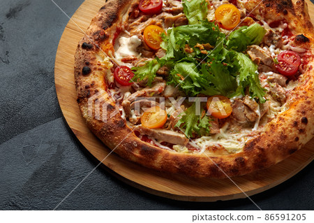 Pizza Caesar. Pizza with chicken, tomato, cheese and lettuce on stone background. Top view. Free space for your text. Delivery food 86591205