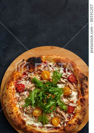 Pizza Caesar. Pizza with chicken, tomato, cheese and lettuce on stone background. Top view. Free space for your text. Delivery food 86591207