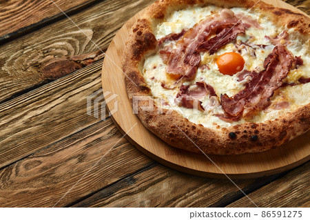 Carbonara pizza with bacon and egg on wooden background Carbonara pizza with bacon and egg on wooden background 86591275