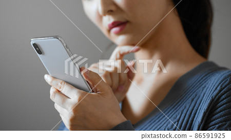 A young woman operating a cell phone A young woman operating a cell phone 86591925