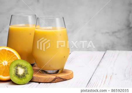 Glass of green banana, orange and kiwi healthy smoothies. 86592035