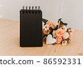 notebook with black sheets with copy space, bouquet of flowers and a white heart. 86592331