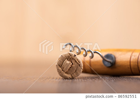 Wine cork and corkscrew on a wooden surface. 86592551