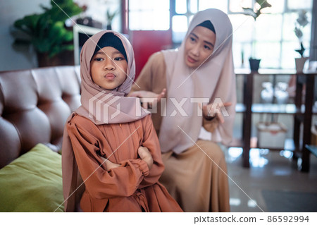 Muslim Angry asian mother sitting with little daughter Muslim Angry asian mother sitting with little daughter 86592994