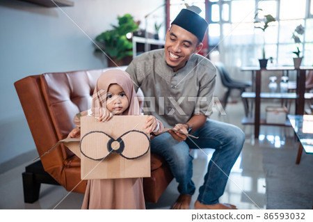 girl with hijab playing with cardboard airplane with dad girl with hijab playing with cardboard airplane with dad 86593032