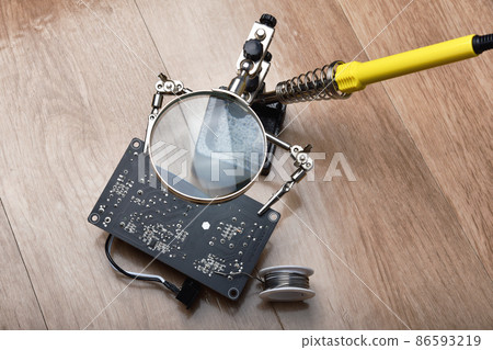 Electronics repair service, Technician fixing electronic circuit board with soldering iron and tin Electronics repair service, Technician fixing electronic circuit board with soldering iron and tin 86593219