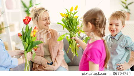 Cute cildren giving the bunches their beautiful mother. Cute cildren giving the bunches their beautiful mother. 86594754