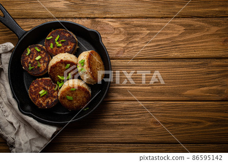 Homemade cutlets from fish, chicken or meat on black cast iron frying pan skillet 86595142
