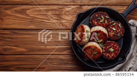 Homemade cutlets from fish, chicken or meat on black cast iron frying pan skillet Homemade cutlets from fish, chicken or meat on black cast iron frying pan skillet 86595154