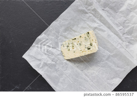 Piece of blue roquefort cheese on black slate plate, copy space Piece of blue roquefort cheese on black slate plate, copy space 86595537