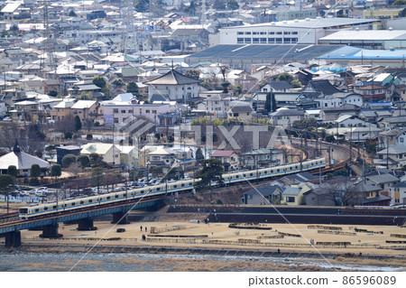 Odakyu Electric Railway 8000 series crossing the Sakegawa Bridge through the curve of a residential area 86596089