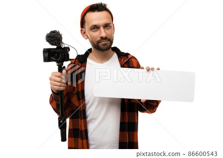 a man blogger in a white T-shirt and shirt in a red and black cage with a video camera and a a man blogger in a white T-shirt and shirt in a red and black cage with a video camera and a 86600543